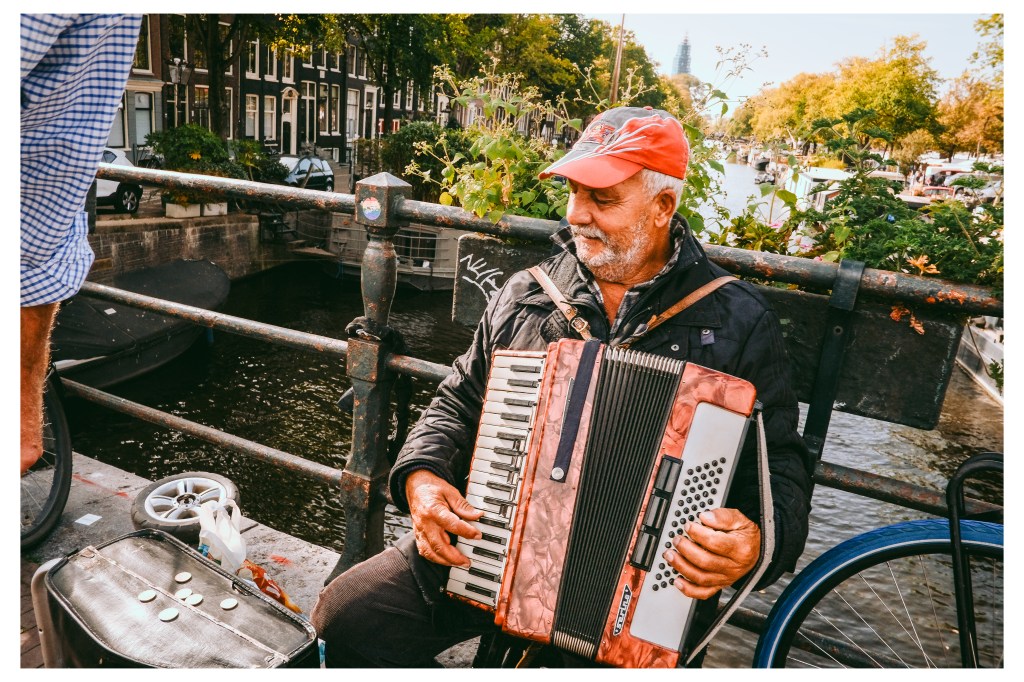 busker on a bridge over a canal in Amsterdam