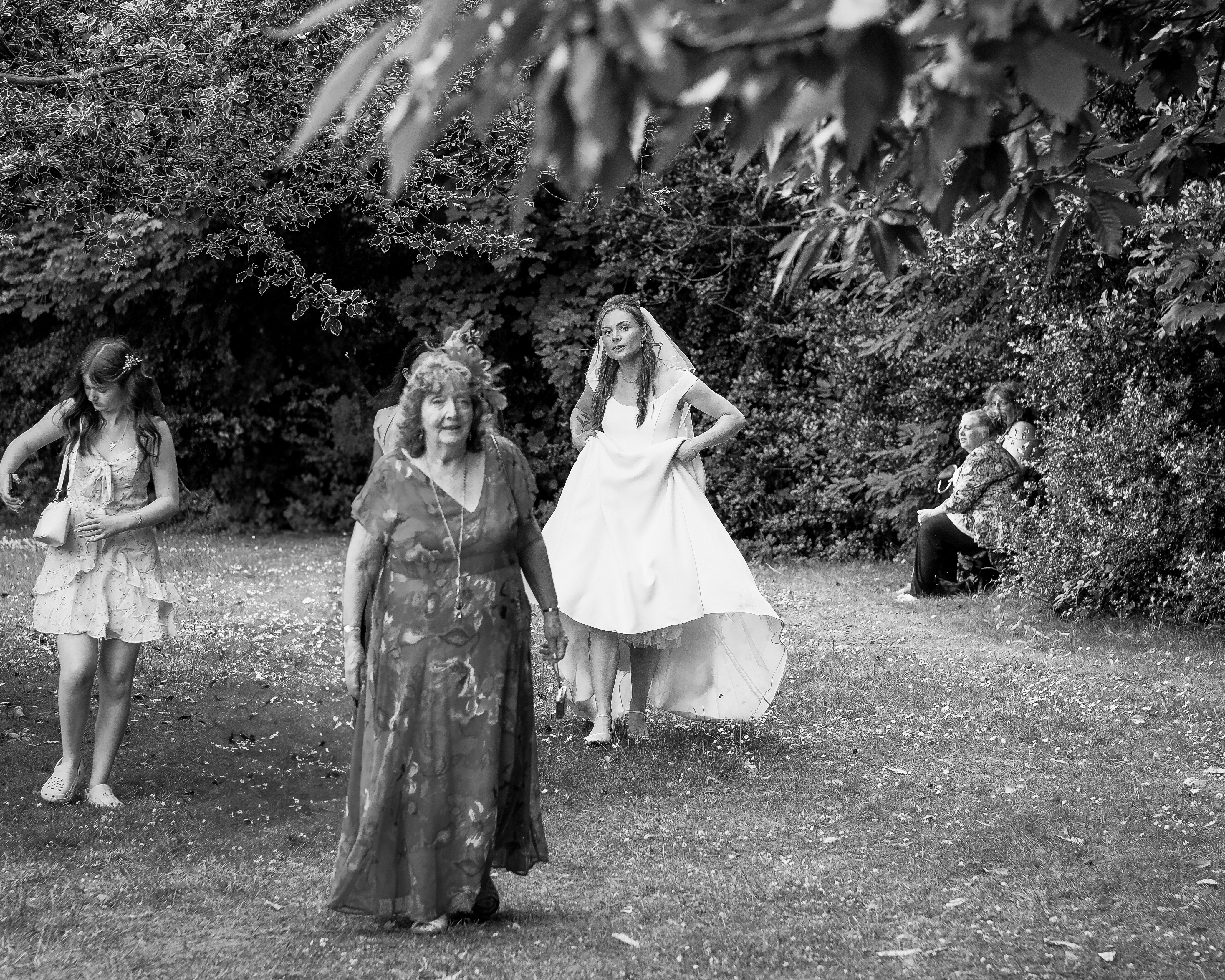 Bride walking through a garden party at her wedding